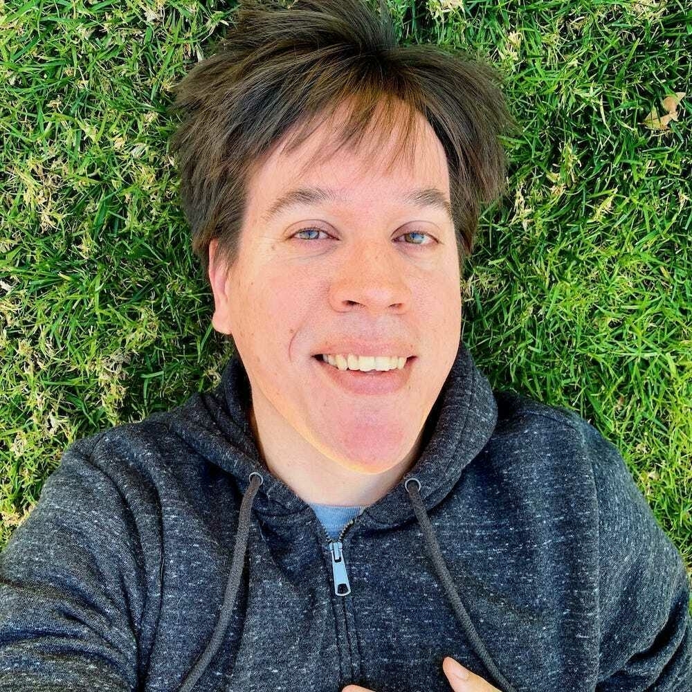 An image of me, Sean, lying on some backyard grass.